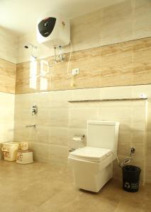 a bathroom with a toilet and a camera on the wall at Chimbalhar Heights in Pālampur