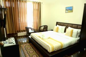 a bedroom with a large bed in a room at Chimbalhar Heights in Pālampur