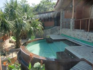 a swimming pool in front of a house at Villa Escondida in Zipolite