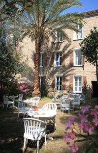 a group of tables and chairs in front of a building at Hôtel Colombo- Porto Corse in Porto Ota