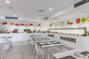restauracja ze stołami, krzesłami i ladą w obiekcie Welikehotel Triton Beach w Cala Ratjada