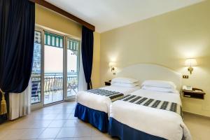 a hotel room with two beds and a balcony at Best Western Hotel La Solara in Sorrento