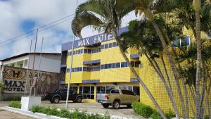 żółty budynek z ciężarówką zaparkowaną przed nim w obiekcie Max Hotel w mieście Arcoverde