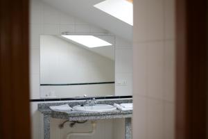 
a bathroom with a sink and a mirror at Hotel Rialta in Culleredo
