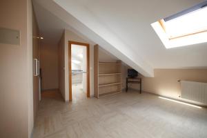 an attic room with a skylight and a hallway at Hotel Rialta in Culleredo