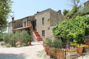 ein altes Steinhaus mit einem Haufen Pflanzen in der Unterkunft Casale San Marco B&B in Piccione