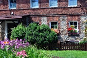 a brick house with flowers in front of it at Gospodarstwo Agroturystyczne Powierzówka in Leśna