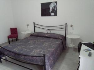 - une chambre avec un lit, deux tables et une chaise dans l'établissement Caltagirone Casa Serena, à Caltagirone