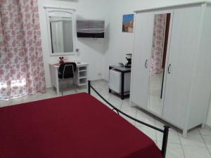 - une chambre avec un lit, un bureau et un miroir dans l'établissement Caltagirone Casa Serena, à Caltagirone