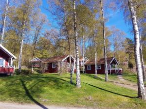 eine Gruppe von Cottages im Wald mit Bäumen in der Unterkunft Svalemåla Stugby in Bräkne-Hoby