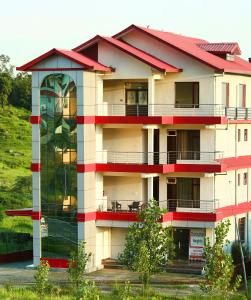 a tall building with a red roof at Chimbalhar Heights in Pālampur