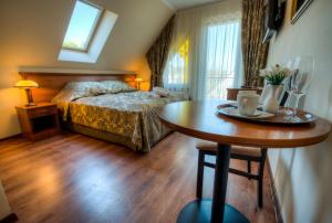 a hotel room with a bed and a table with a tableasonable at Villa Meridian in Trzęsacz