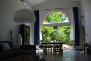 ヴァロン・ポン・ダルクにあるla maison bleueのリビングルーム(テーブル、大きな窓付)