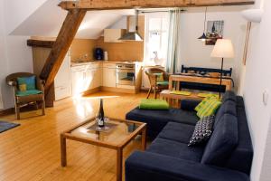 sala de estar con sofá azul y mesa en Ferienwohnung Weis en Zell an der Mosel
