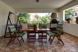 a wooden table and chairs on a patio at Kouros Studios in Kavála