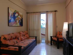 een woonkamer met een bank en een tv bij Aparthotel Eporedia in Natal