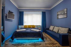 a blue bedroom with a bed and a couch at Luxury Air-Conditioned rooms in Old Town Bratislava in Bratislava