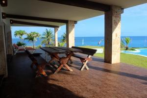 a picnic table on a porch with the ocean in the background at Relax On The Caribbean in Río San Juan