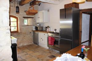 een keuken met een roestvrijstalen koelkast en een fornuis bij La Batonnerie in Civray