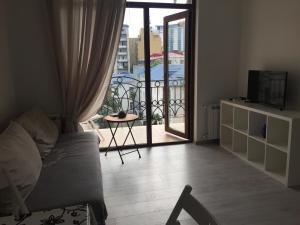 una sala de estar con una puerta que da a un balcón en Love at First Sight Apartment en Batumi