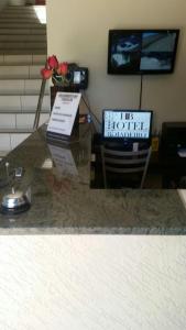 a counter top with a television in a room at Hotel Boiadeiro in Araguaína