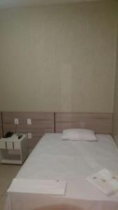 Un pat sau paturi într-o cameră la Hotel Boiadeiro