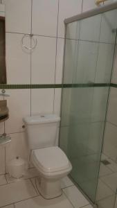 uma casa de banho com um WC e uma cabina de duche em vidro. em Hotel Boiadeiro em Araguaína