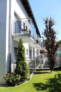 een wit gebouw met een balkon en een boom bij Villa Stella Baltica in Władysławowo