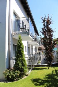 a white building with a balcony and a tree at Villa Stella Baltica in Władysławowo