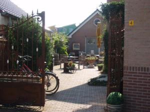 a bike is parked in a courtyard with a gate at Logement Brocante in De Koog