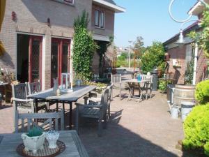 a patio with a table and chairs in front of a house at Logement Brocante in De Koog