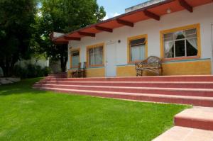 a house with stairs in front of a yard at Posada San Francisco in Tequisquiapan