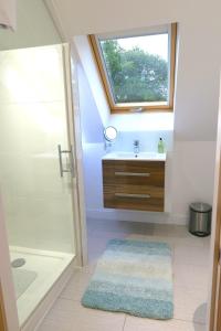 a bathroom with a sink and a shower and a window at Badgers Den in Linlithgow