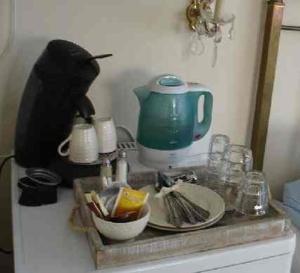 - un comptoir avec une théière et de la vaisselle dans l'établissement Logement Brocante, à De Koog