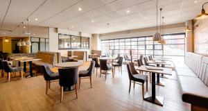 a restaurant with tables and chairs in a room at Castlefield Hotel in Manchester