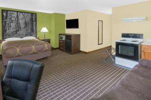 a hotel room with a bed and a couch at Super 8 by Wyndham Webster City IA in Webster City