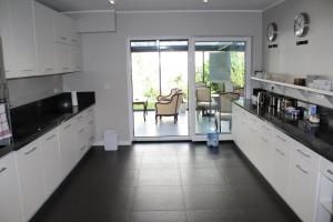 a kitchen with white cabinets and a dining room at Villa Stella Baltica in Władysławowo