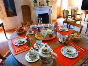 a dining room table with tea sets on it at Chez Casimir in Cercy-la-Tour