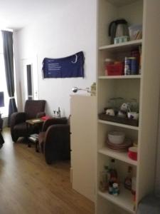 a living room with a couch and a shelf at Appartement centrum Groningen in Groningen