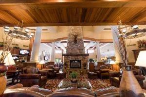 a lobby with a fireplace and leather chairs at MCM Elegante Lodge & Resorts in Ruidoso