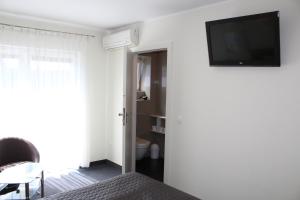 1 dormitorio con 1 cama y TV en la pared en Villa Stella Baltica, en Władysławowo