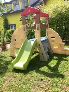 a wooden playground with a slide in the grass at Ubytování U draka in Třeboň