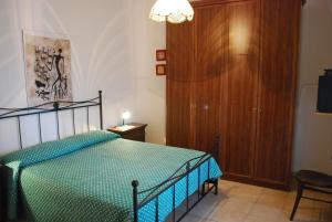 a bedroom with a bed and a wooden cabinet at Casa Piera con vista mare da 2 a 4 persone in Badesi