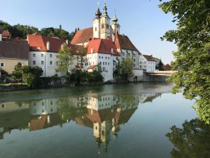 a castle reflecting in the water of a river at New flat in old town+garage in Steyr