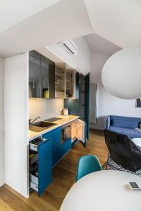 a kitchen with blue cabinets and a blue couch at Zydroji Pakrante in Nida