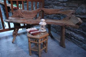 una panca di legno con una lampada su uno sgabello di Mi Casa Tu Casa a Brusson