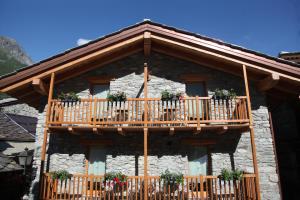 a building with a balcony with flowers on it at Mi Casa Tu Casa in Brusson