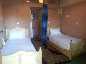 two beds in a room with two beds sidx sidx sidx sidx at Auberge Des Jardins du Dades in Boumalne