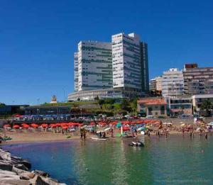 a group of people on a beach with umbrellas at Radar Mirador Cabo Corrientes in Mar del Plata