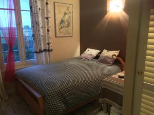um pequeno quarto com uma cama e uma janela em Le Chant Des Oiseaux em Magny-les-Hameaux